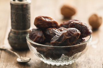 Dry dates on a bowl on a vintage or rustic table top wood background