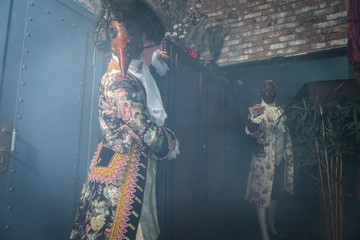 Actors in Steam punk masks and antique costumes indoor.