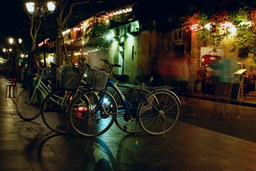 Fototapeta na wymiar bicycles on a night street with colored lights in tourist Vietnamese town Hoi An
