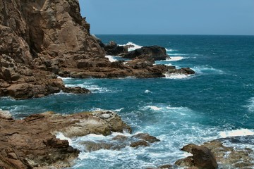 bright blue sea with sharp cliffs