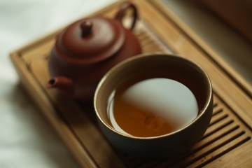 clay tea pot and cup of chinese tea pu erh on the wooden table for tea ceremony