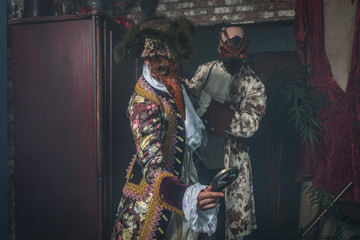 Actors in Steam punk masks and antique costumes indoor.