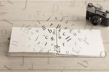 Open notebook on the floor with office instruments nearby and letters on it