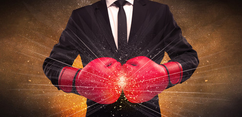 A successful powerful business person in red boxing gloves concept with illustrated power lines and pieces falling apart in front of explosion.