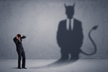 Fototapeta premium Business man looking at his own devil demon shadow concept background