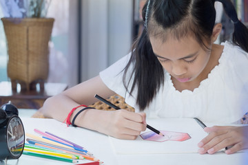 Asian Girl Sitting and Finishing Her Homework, Learning Concept