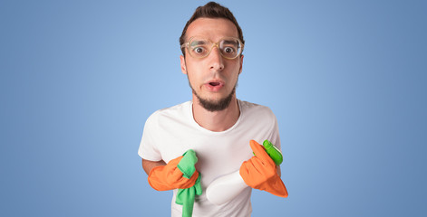 Housekeeper with cleaning product and equipment in front of a blue empty wall
