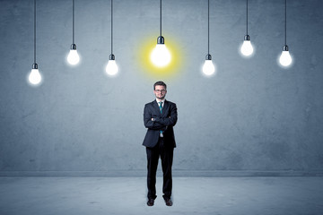 Fototapeta premium Handsome businessman in an empty space with bulbs above and uninspired face 