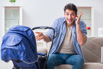 Young father looking after newborn baby at home