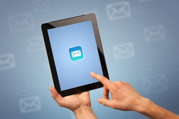 Female fingers touching tablet with mail icon on it 