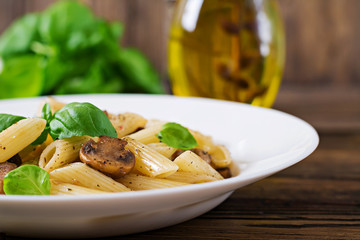 Vegetarian Vegetable pasta penne  with mushrooms  in white bowl on wooden table. Vegan food.