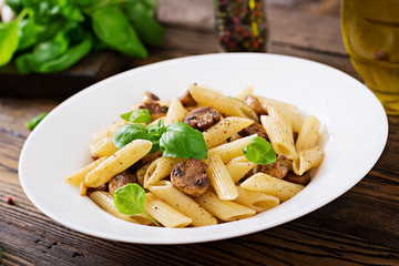 Vegetarian Vegetable pasta penne  with mushrooms  in white bowl on wooden table. Vegan food.