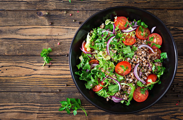 Buckwheat salad with cherry tomatoes, red onion and fresh herbs. Vegan food. Diet menu. Top view. Flat lay