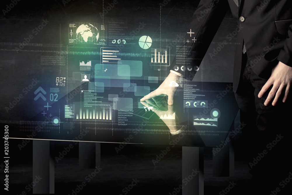 Poster businessman touching interactive modern desk with technology icons on table