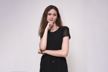 Portrait of a beautiful brunette girl on a gray background showing disbelief.