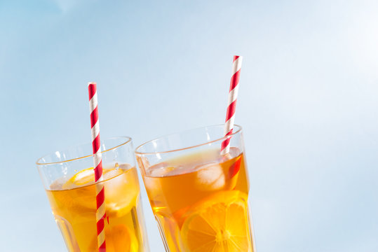 iced tea with lemon in clear glasses on blue background