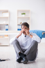 Doctor sitting on the floor in hospital