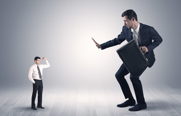 Big debutant young businessman scared of small strong businessman
