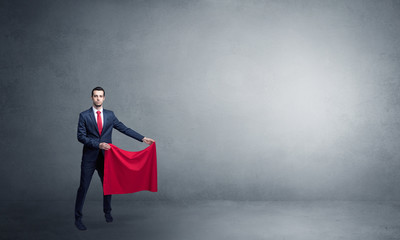 Obraz premium Businessman standing with red toreador cloth in his hand in an empty room 