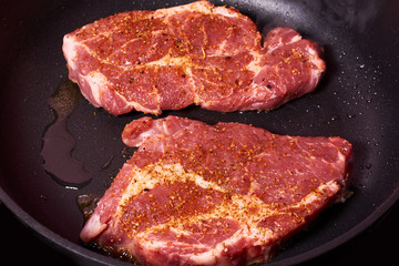 fresh raw beef steak with spices on frying pan. organic farm