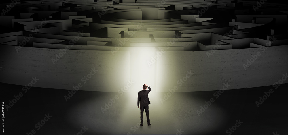 Wall mural businessman getting ready to enter a concentric labyrinth with lighted entrance concept