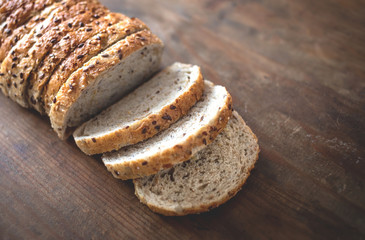 Top view of sliced wholegrain bread on dark ructic wooden  background closeup.