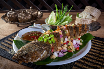fried fish with herb and spicy sauce, thai food.