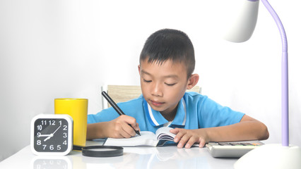 Happy kid thinking for do home work on table on white background