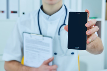 Male doctor's hand showing a blank smart phone screen.