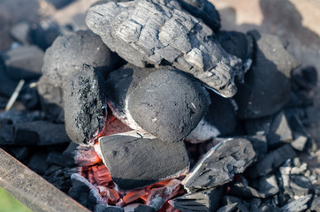 Close up of flaming briquette on the grill