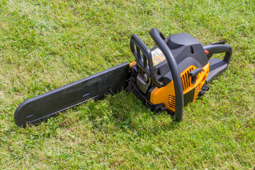 Black and orange chainsaw on grass