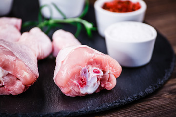 Raw chicken drumsticks on wooden background