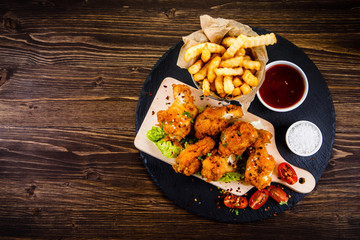 Fried chicken drumsticks with French fries and vegetables