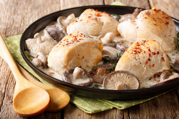 Rustic food: chicken fillets with a mix of wild mushrooms and spinach with gravy closeup on a plate. horizontal