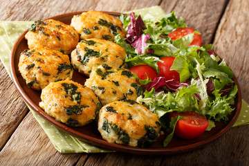 Homemade chicken balls with spinach and cheese and vegetable salad close-up on a plate. horizontal