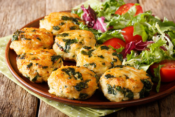 Dietary tasty meat balls with spinach and vegetable salad close-up on a plate. horizontal