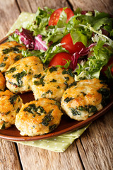 chicken balls with spinach and a salad of fresh vegetables close-up. vertical