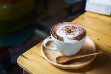 Coffee cup on the wooden table with soft light.