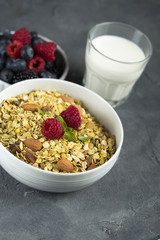 Homemade granola with fresh berries and mint, served with milk