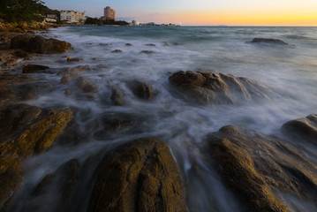 wave at the sea on the rock with sunset sky