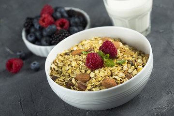 Homemade granola with fresh berries and mint, served with milk