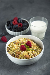 Homemade granola with fresh berries and mint, served with milk