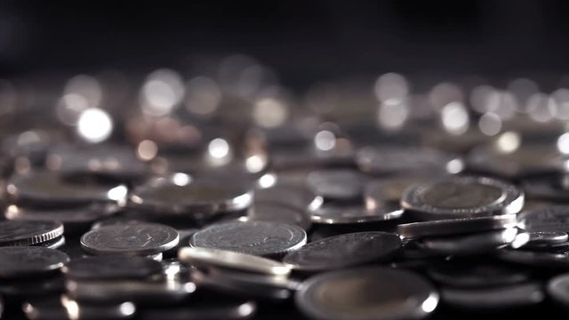 pan shot of close up money coin stacking on  the floor in dark light , business and financial for money saving or the investment background concept  , extremely close up and shallow DOF