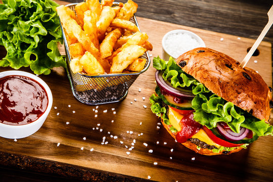 Tasty burger with chips served on cutting board