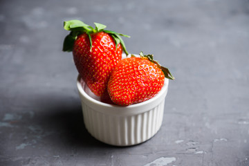 Ripe strawberries in small bowl on the rustic background. Selective focus.