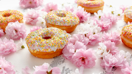 Sweet pink fresh Donut decorated with japanese Flowering Cherry Tree flower