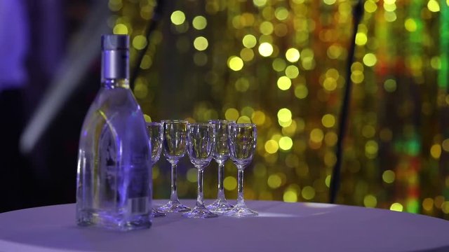 Bottle of liquor on the table, a bottle of vodka and wine glasses on a buffet table