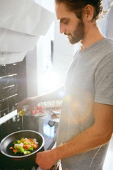 Handsome Man Cooking Breakfast At Home In Kitchen.