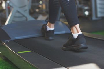 Fototapeta premium Woman runs on the treadmill in the gym