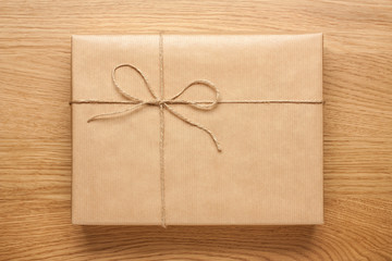 Big gift box wrapped in kraft paper on wooden table